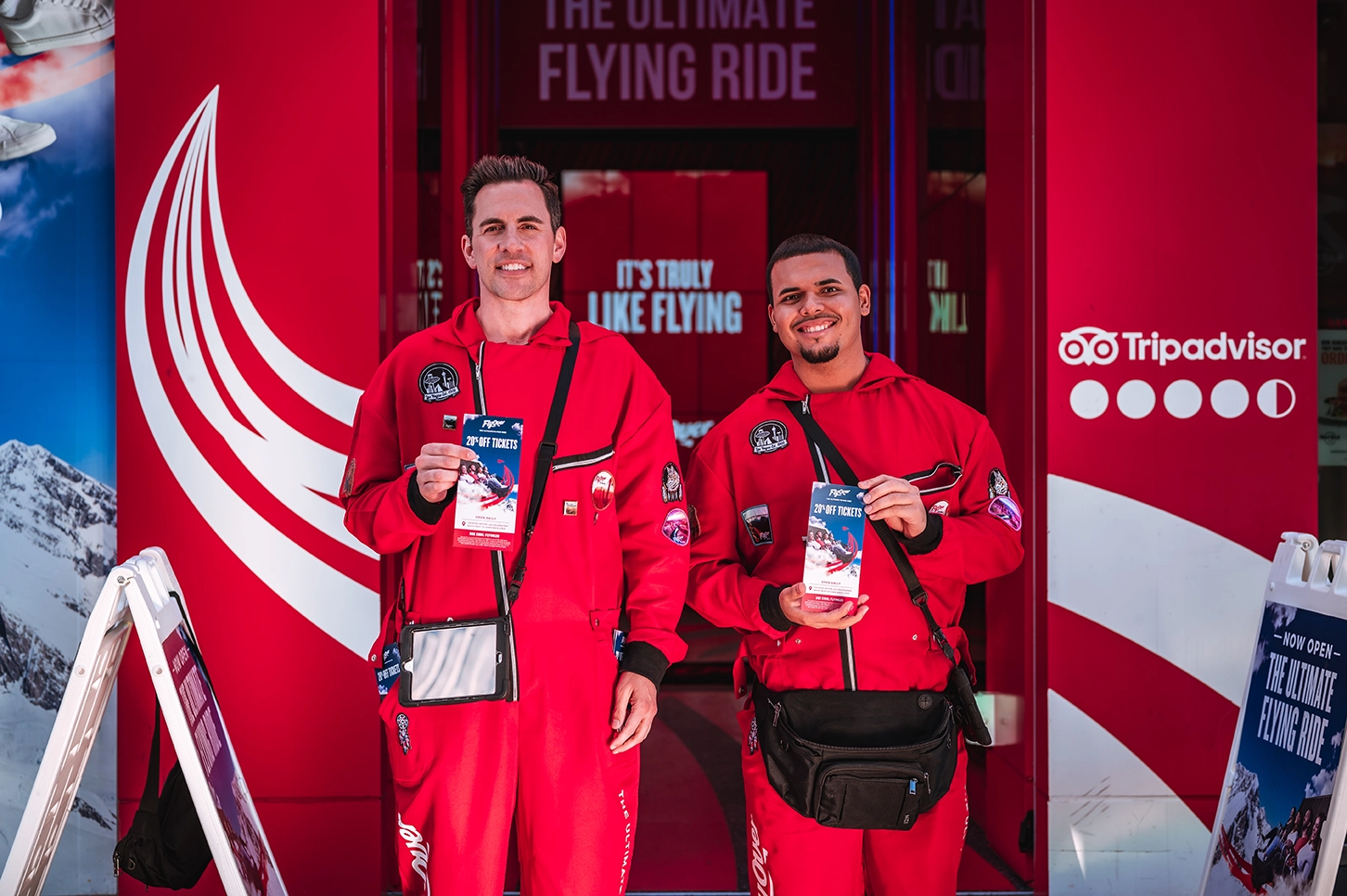 Two men promote flying ride with tickets.