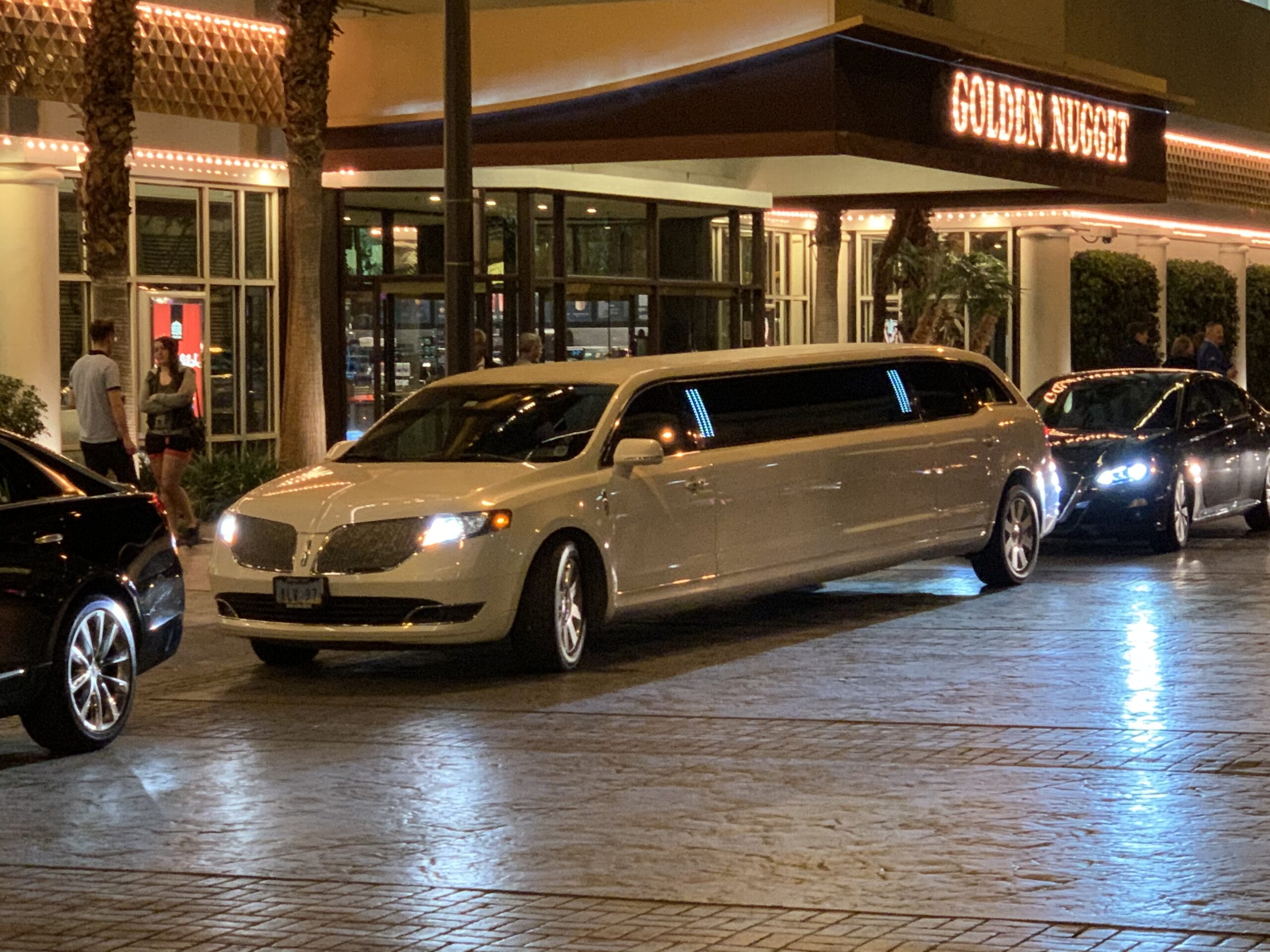 White limo outside Golden Nugget hotel at night.