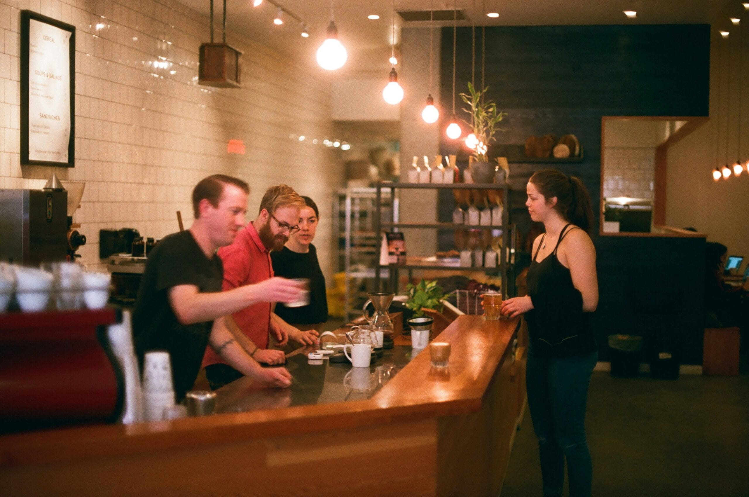 People talking at a coffee shop counter.