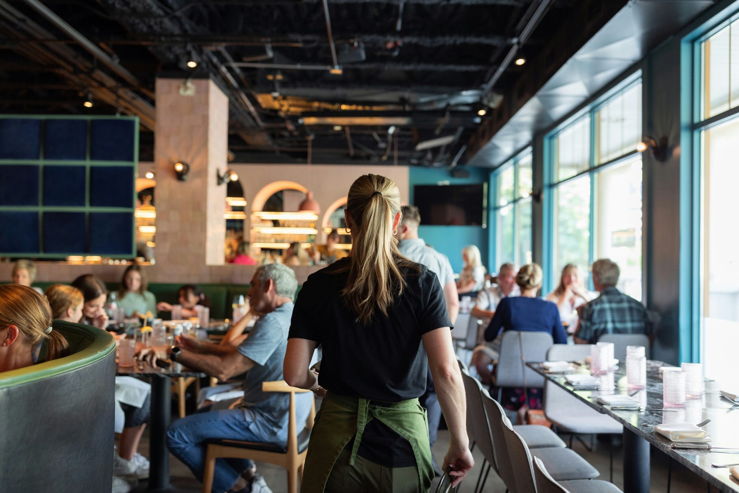 Waitress serving customers in a busy restaurant.