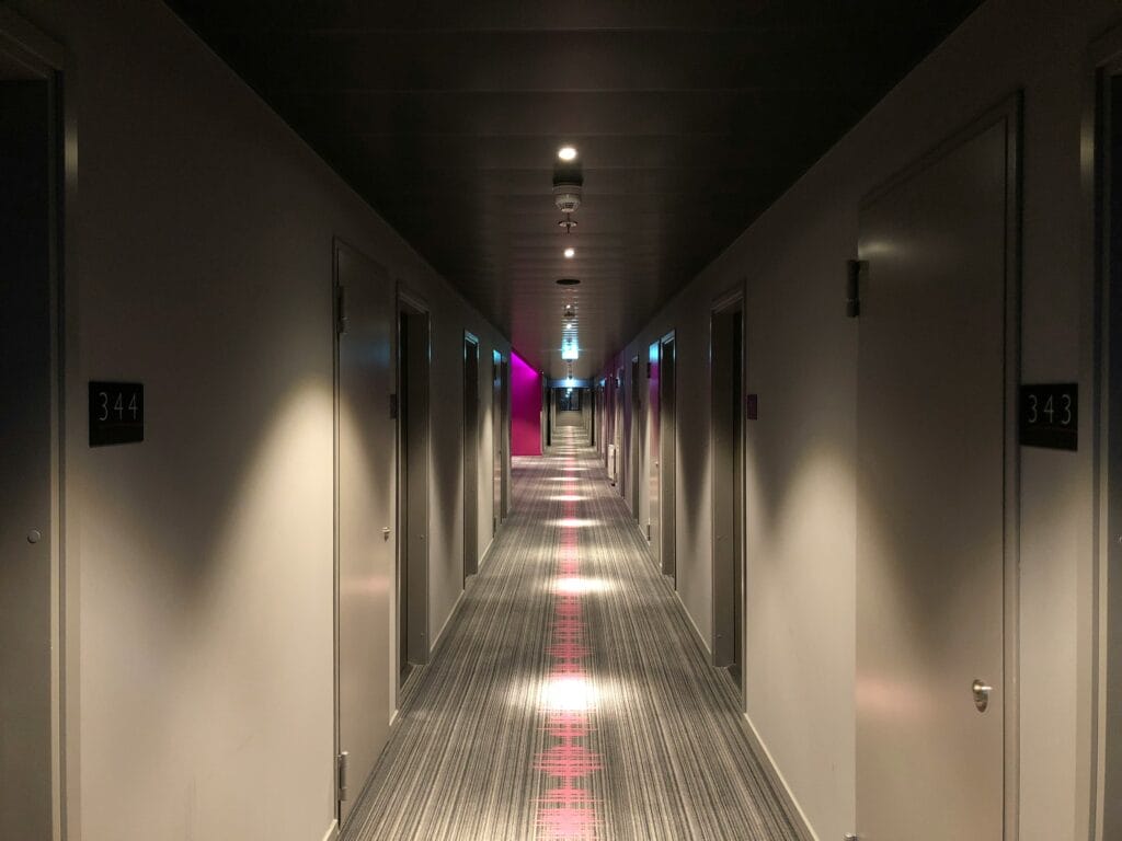 Dimly lit hotel hallway with room doors